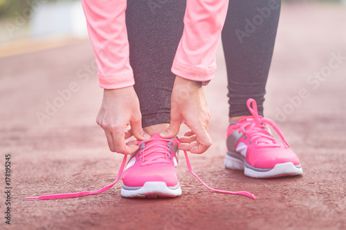 Fitness woman tying running shoe laces