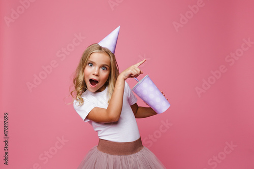 Wall Mural Portrait of a happy little girl in a birthday hat