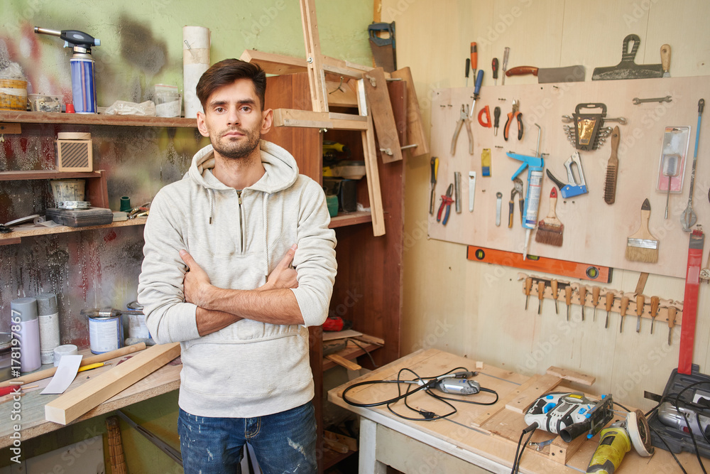 Portrait of a guy working in a home workshop.