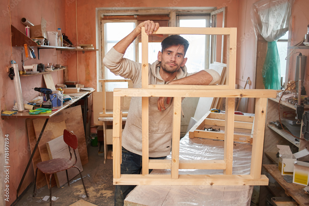 Portrait of a guy working in a home workshop.