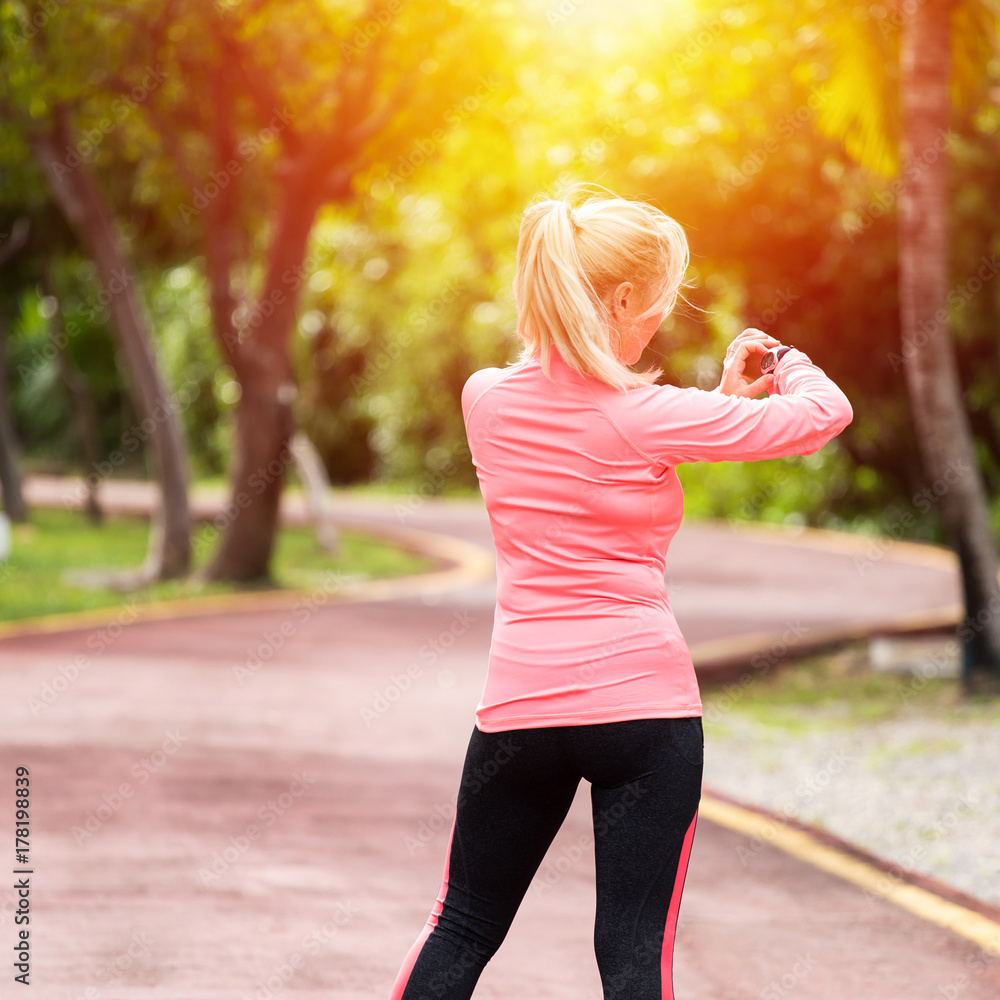 Sports athlete runner woman looking at heart rate monitor after jogging Sports athlete runner woman looking at heart rate monitor after jogging