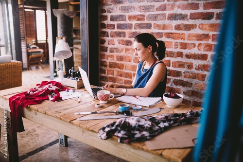 Young busineswoman working on laptop at desk in office photo