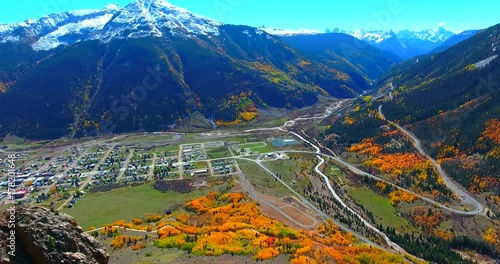 Colorado City In Snow-Capped Mountain Valley With Bright Orange Trees During Autumn - Aerial Approaching View - Silverton, Colorado, USA photo