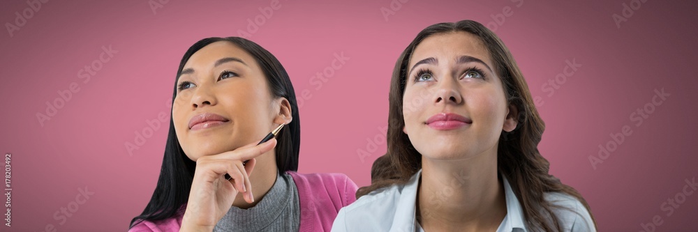 Two women looking up with pink background Two women looking up with pink background