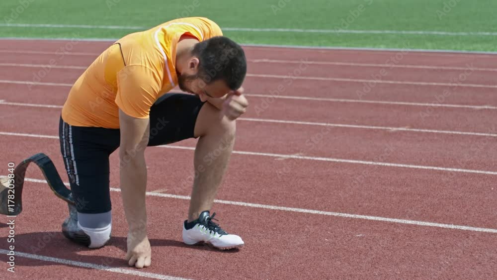 Amputee athlete with prosthetic limb standing on one knee while suffering from pain in leg and then standing up and walking Amputee athlete with prosthetic limb standing on one knee while suffering from pain in leg and then standing up and walking