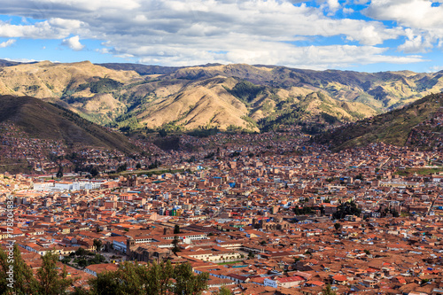 Red roof houses of Cuzco city in the valley and Andes panorama, Peru
