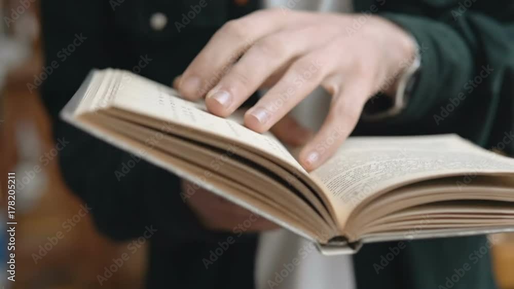 Close up view of students hands holding book and turning pages, reading concept Close up view of students hands holding book and turning pages, reading concept
