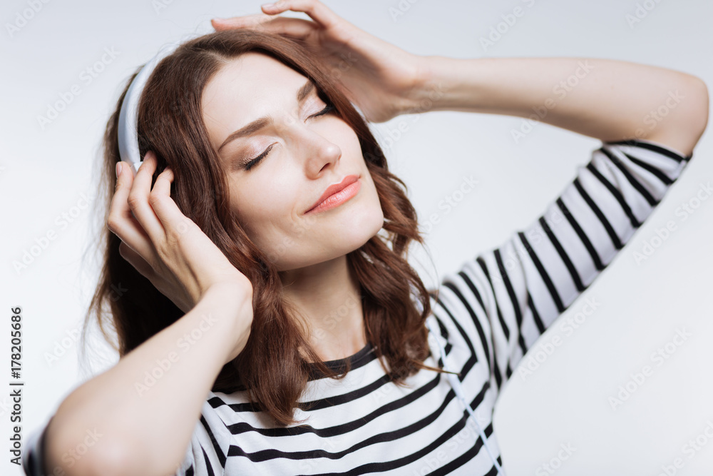 Fototapeta premium Beautiful auburn-haired woman enjoying music
