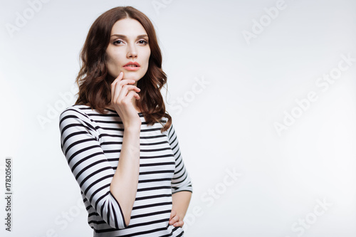 Charming woman touching her chin while posing