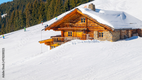 Traditional wooden alpine chalet on sunny winter day. Alps, Europe.
