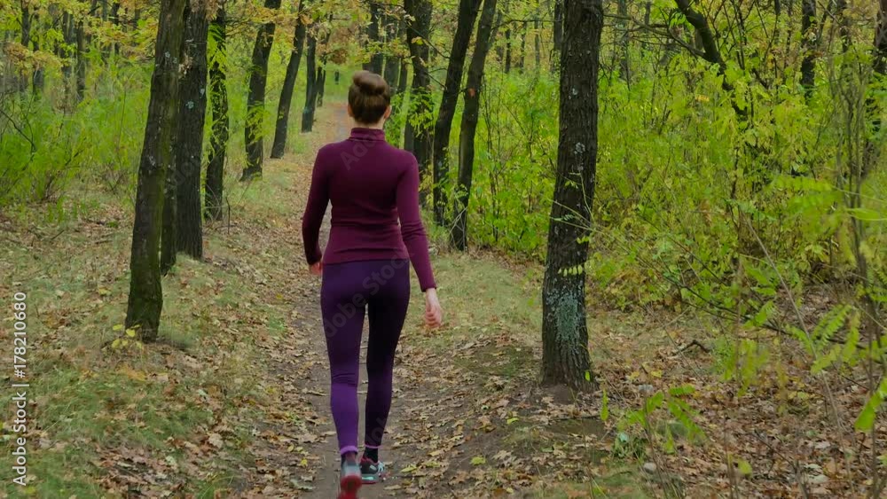 Running - woman runner jogging on autumn forest path. Fit female sport fitness model athlete trail running training. Runner gril in sportswear running in park exercising outdoors. Running - woman runner jogging on autumn forest path. Fit female sport fitness model athlete trail running training. Runner gril in sportswear running in park exercising outdoors.