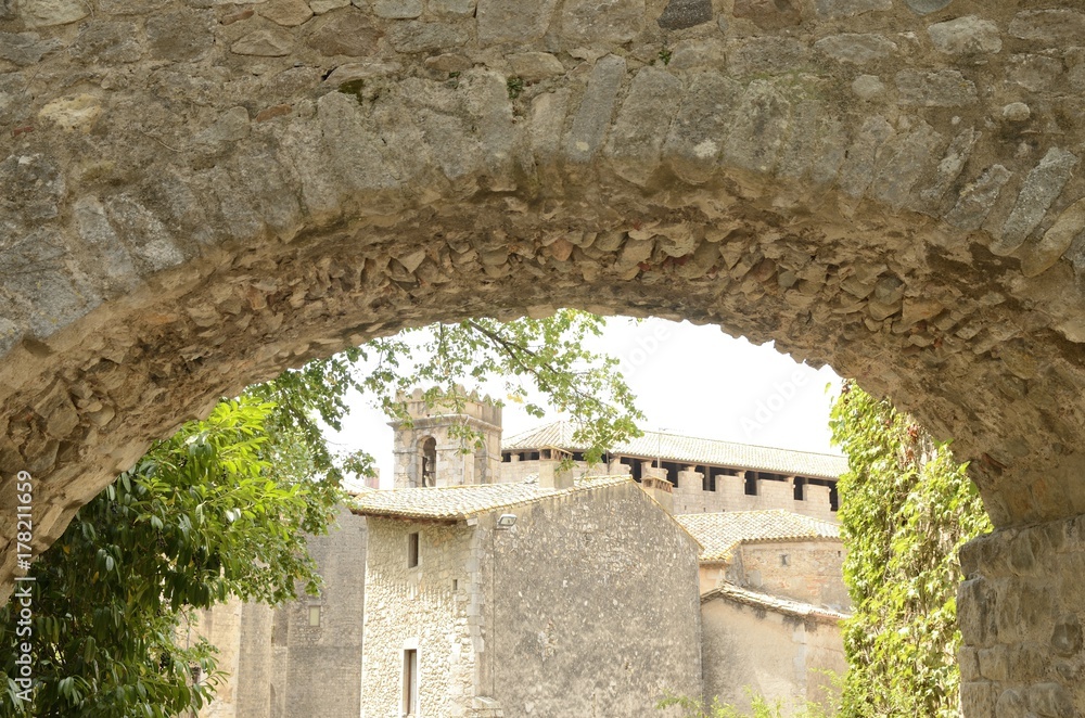 Stone buildings through arch in Girona, Spain