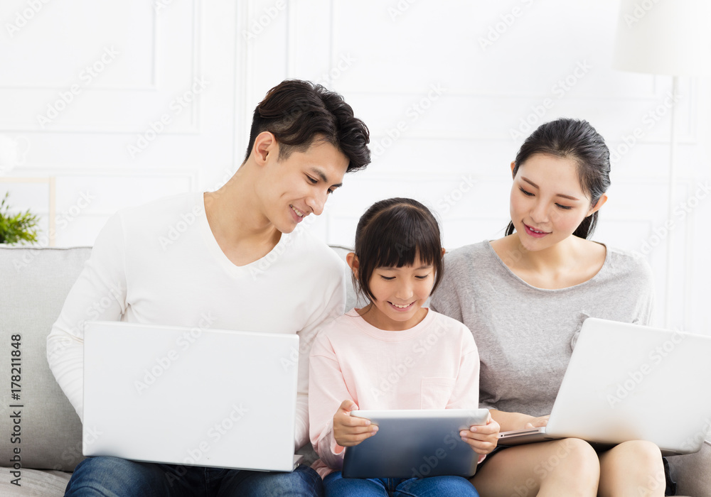 Fototapeta premium Happy asian family with laptop on sofa.