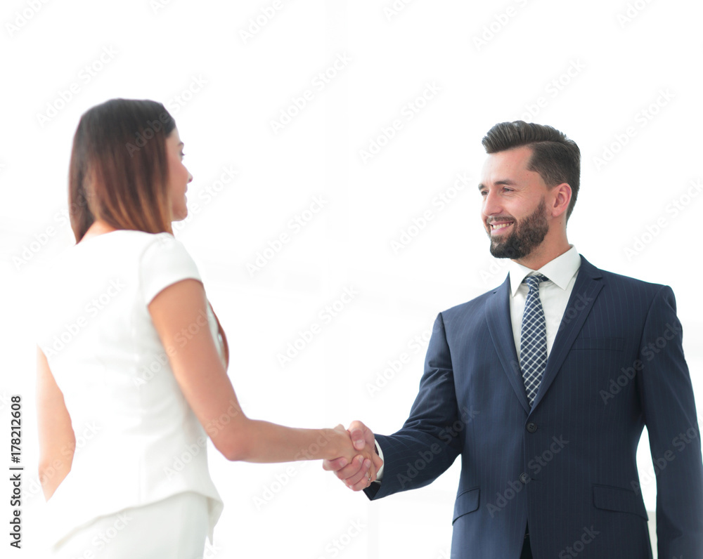 An attractive business man and woman team shaking hands