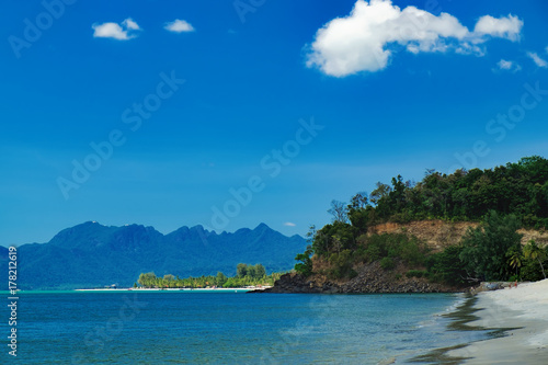 Seascape with islands on the horizon in Pantai Tengah Beach, Langkawi Island, Malaysia. The blue lagoon on the tropical coast of the Andaman Sea