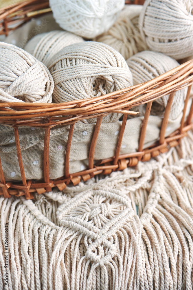 Obraz premium Handmade macrame braiding, background thread on a wooden Board top view