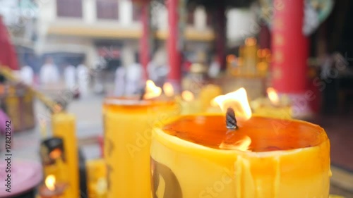 Burning Candles near Buddhist Temple. Thai Religion Background Concept. 4K Flame in Slow Motion. photo