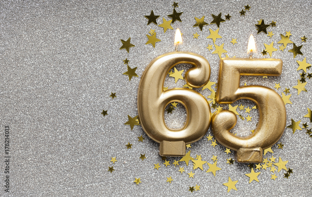 Number 65 gold celebration candle on star and glitter background Stock