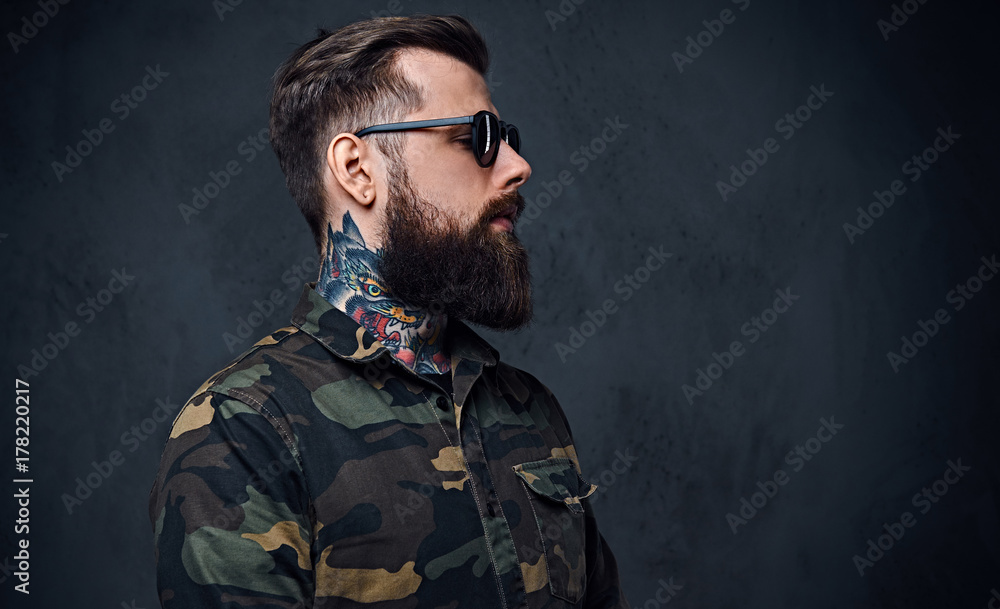 Portrait of bearded tattooed hipster male dressed in a military Portrait of bearded tattooed hipster male dressed in a military
