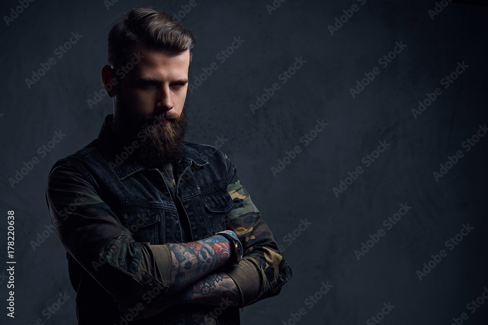Portrait of bearded tattooed hipster male dressed in a military Portrait of bearded tattooed hipster male dressed in a military