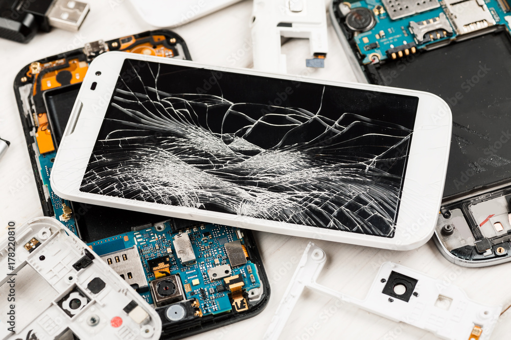 Cell phone with broken display among disassembled gadgets