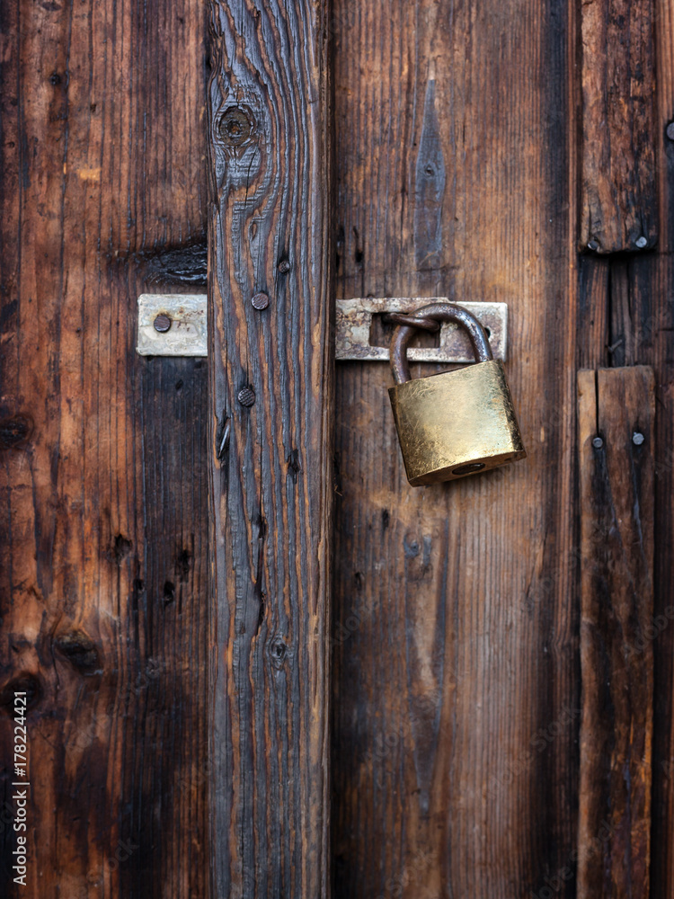 Old dark brown wooden door with padlock. Old dark brown wooden door with padlock.