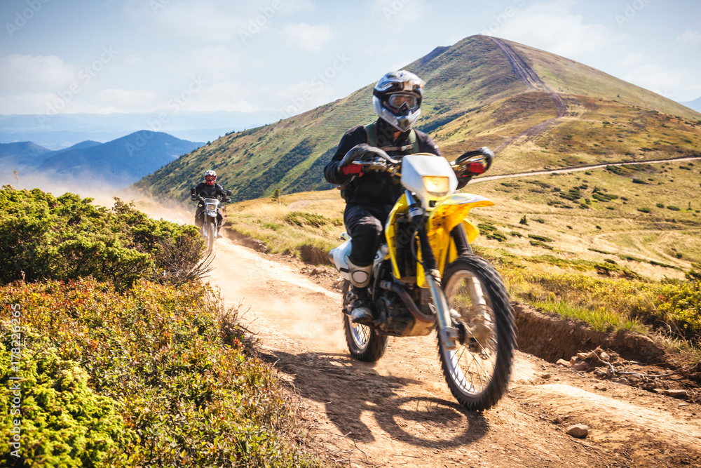 Fototapeta premium Enduro bikers crossing road in Carpathian mountains.
