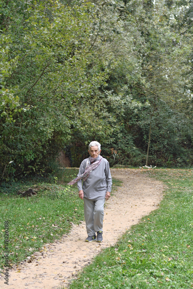 old woman walking in a park old woman walking in a park
