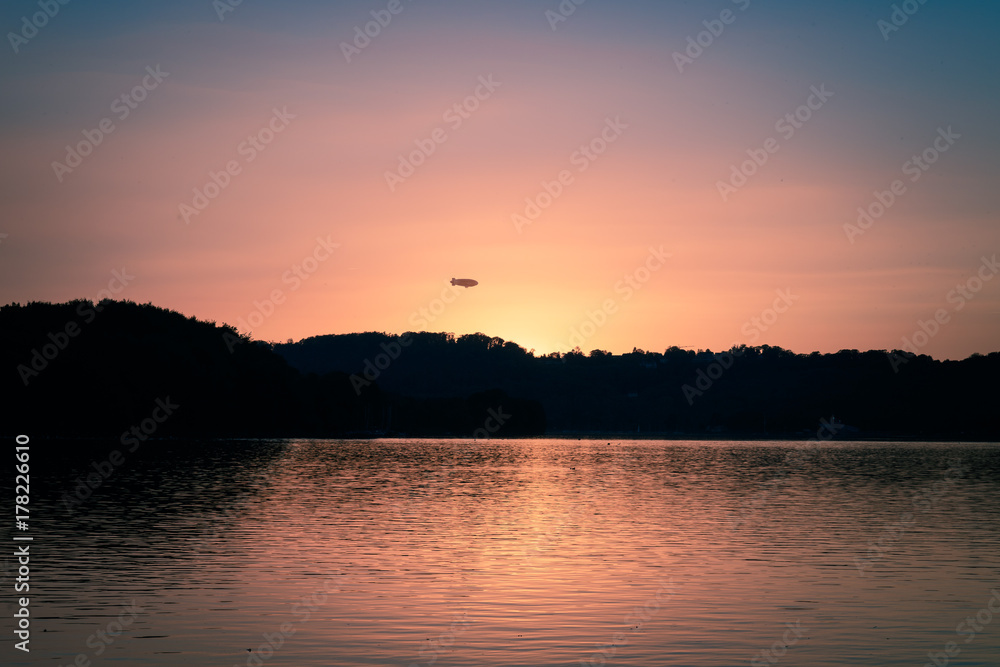 Zeppelin im Sonnenuntergang am See