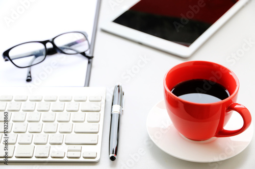 Red Coffee Cup on the desk Business Workspace background in Office Morning work