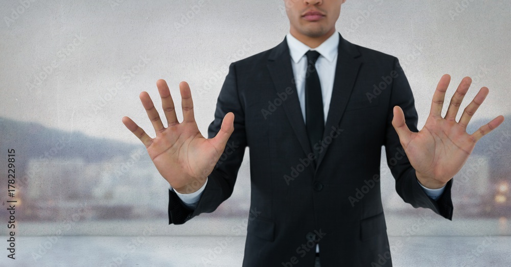 Businessman touching air with open hands in front of city Businessman touching air with open hands in front of city