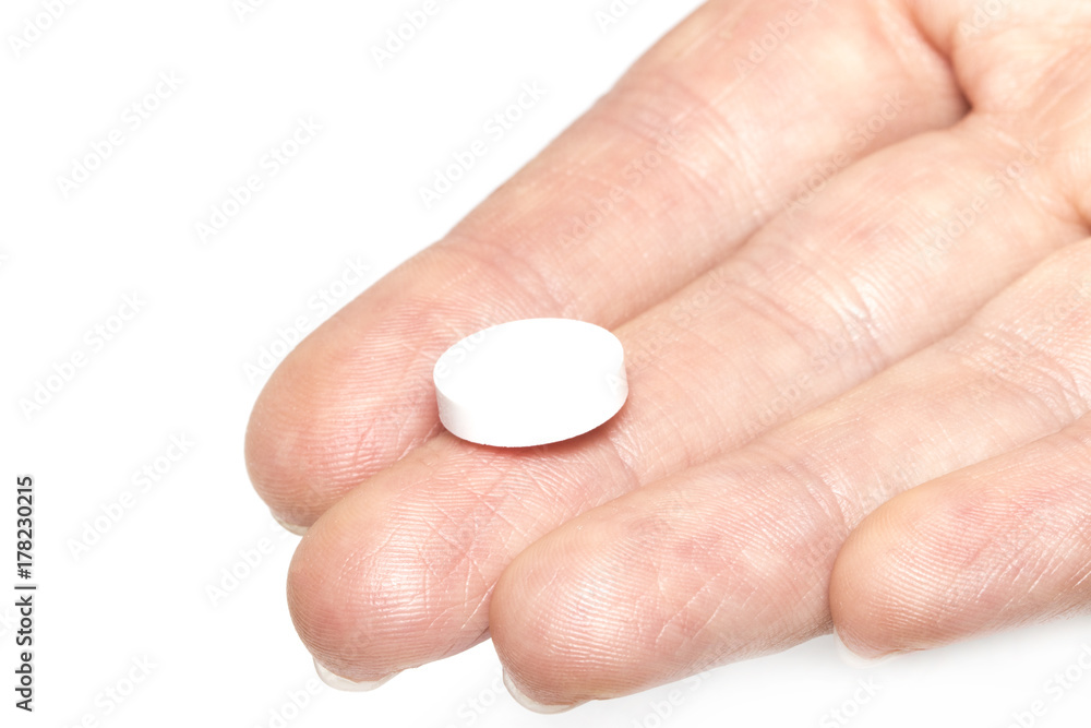 female hand holding one white medicinal tablet in the palm of the hand female hand holding one white medicinal tablet in the palm of the hand