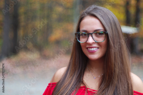 girl smiling brown hairs wearing glasses outside autumn