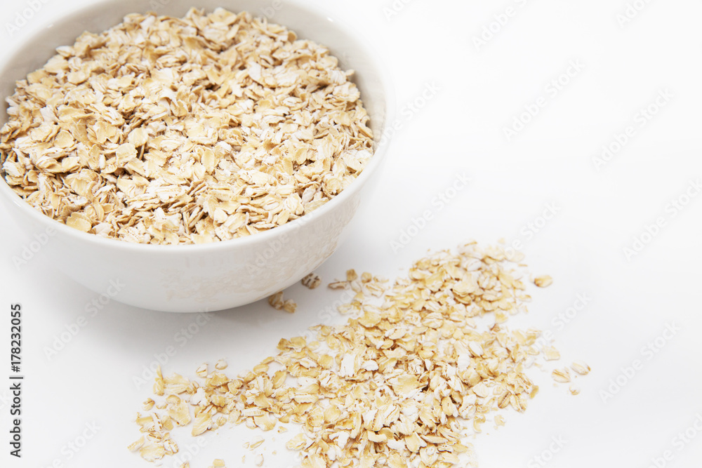 oat flakes in a white bowl on a white background oat flakes in a white bowl on a white background