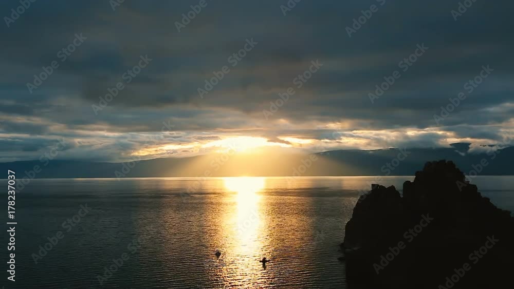 Beautiful colorful sunset at the Lake Baikal with dramatic clouds and sun shining. Full color clouds of twilight sky. Beautiful colorful sunset at the Lake Baikal with dramatic clouds and sun shining. Full color clouds of twilight sky.