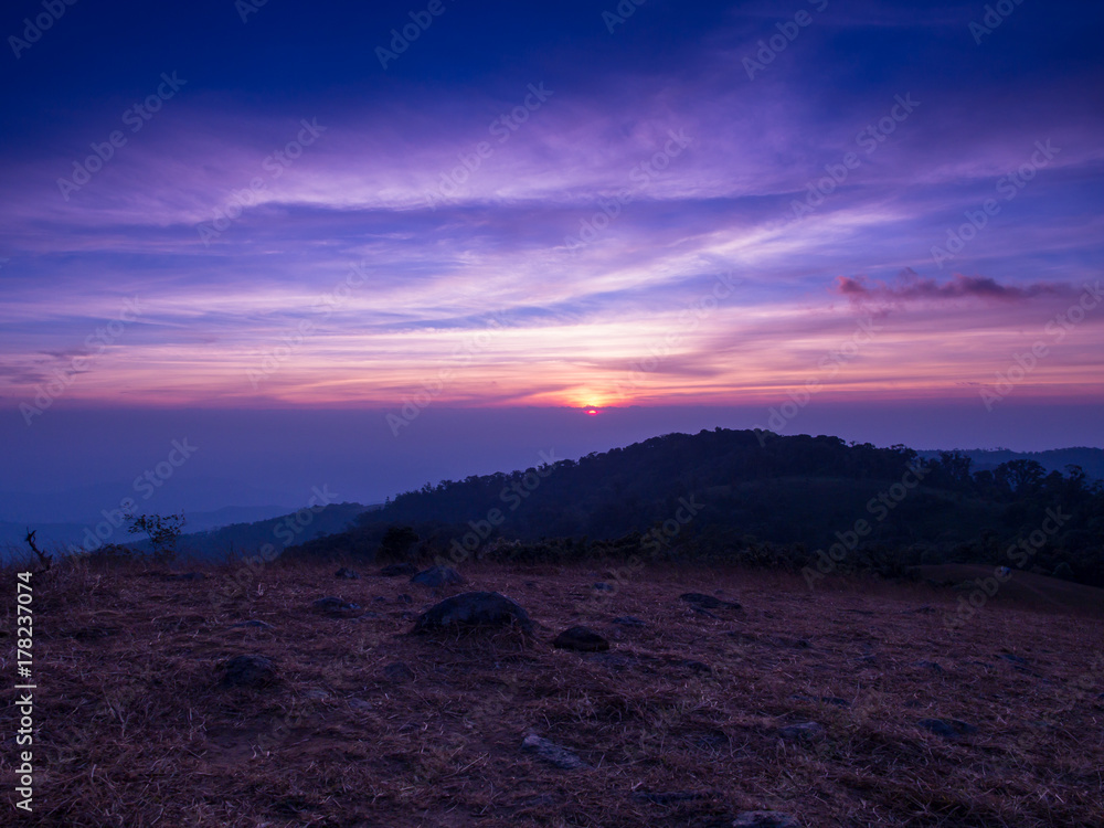 The hiding sun behind the mountain with colorful sky in Mon Jong, Chiangmai, Thailand.