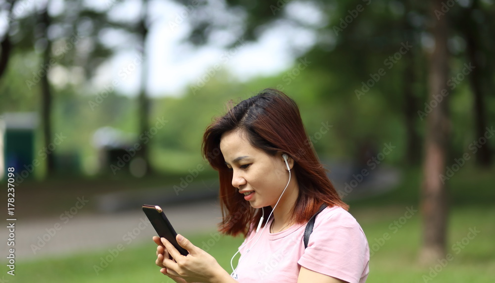 スマートフォンで音楽を聴く女性 スマートフォンで音楽を聴く女性