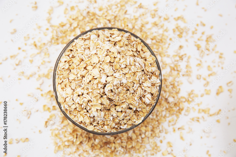 oat flakes in a transparent bowl on a white background oat flakes in a transparent bowl on a white background