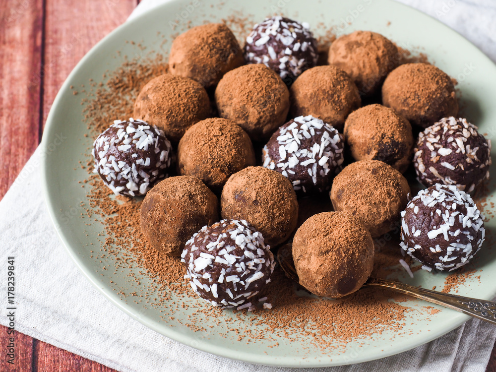 Homemade chocolate truffles with cocoa and coconut on the plate Homemade chocolate truffles with cocoa and coconut on the plate