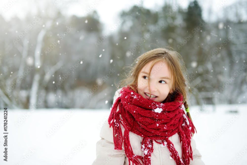 Adorable little girl having fun in beautiful winter park. Cute child playing in a snow. Adorable little girl having fun in beautiful winter park. Cute child playing in a snow.