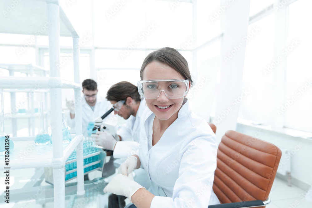 Obraz premium Investigator checking test tubes, Woman wears protective goggles