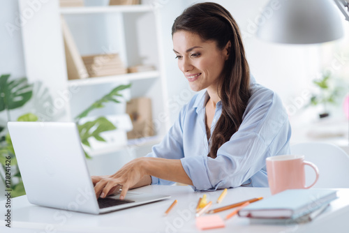 Positive attractive woman using a laptop