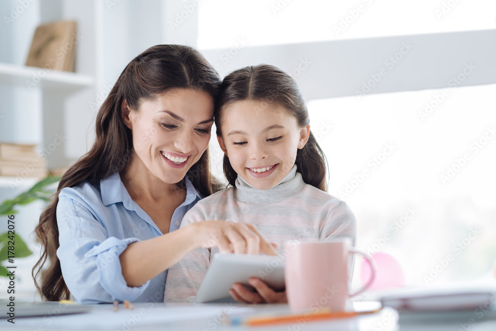 Happy beautiful woman reading a book with her daughter Happy beautiful woman reading a book with her daughter