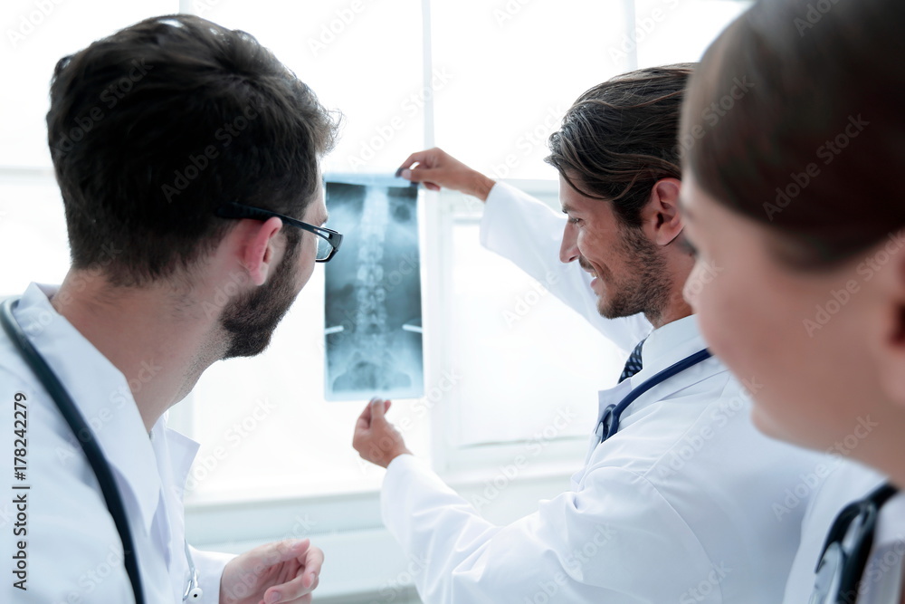 Portrait of happy surgeons holding x-ray report Portrait of happy surgeons holding x-ray report