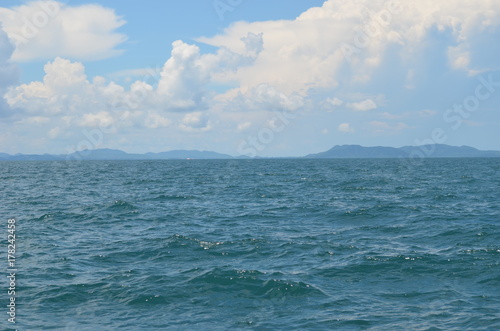 The vastness of the ocean is depicted in this picture with an expanse of the blue water and white clouds