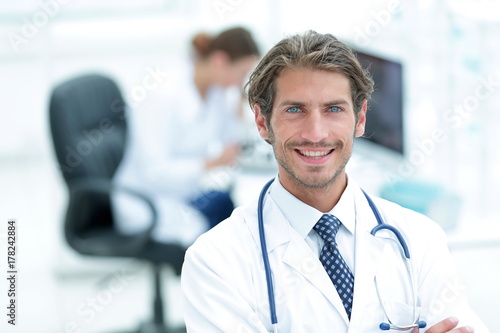 Handsome male doctor smiling with arms crossed on chest portrait