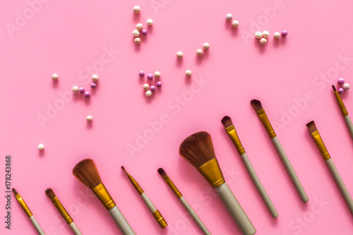 Natural makeup. Ball blushers and brushes pattern on pink background top view