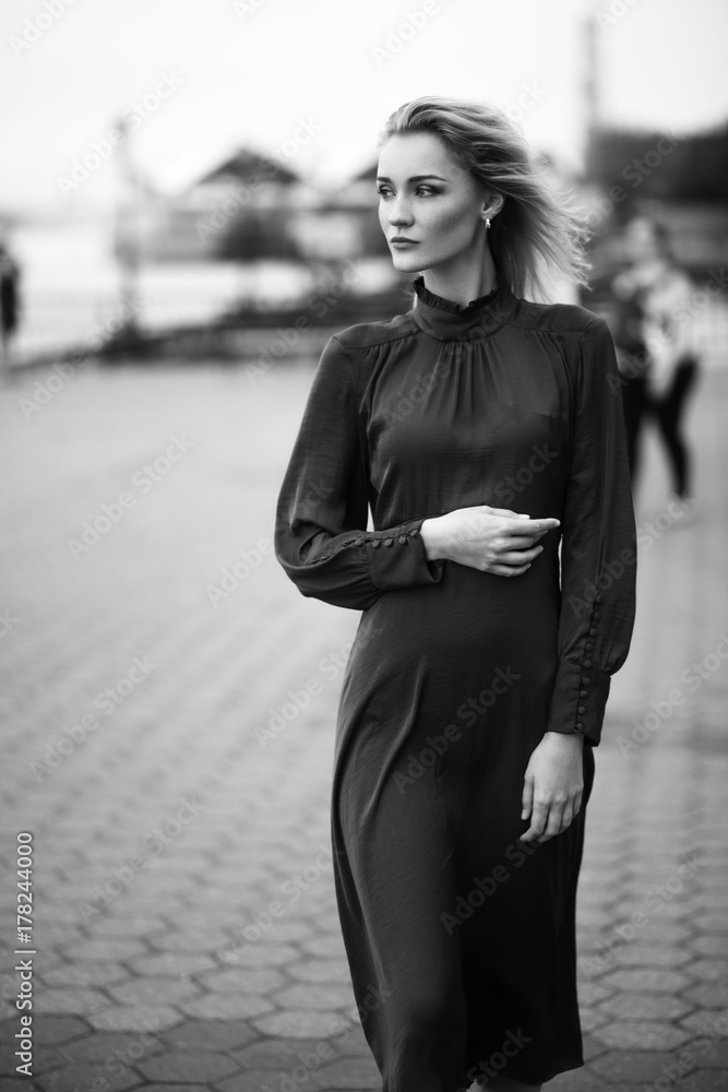 Woman in a dress looks stunning posing against the wind Woman in a dress looks stunning posing against the wind
