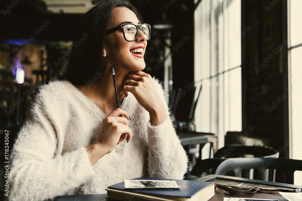 Happy beautiful woman makes some notes sitting in the cafe Happy beautiful woman makes some notes sitting in the cafe