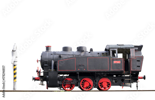 Old steam locomotive and water pump isolated on tracks